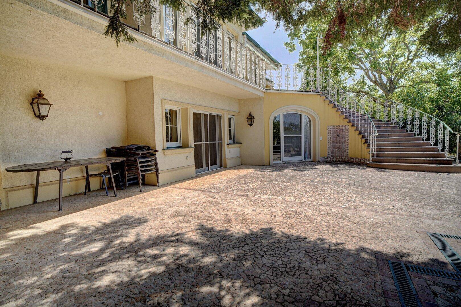 Große gepflasterte Terrasse mit Außentreppe und Sitzgelegenheiten im Freien.