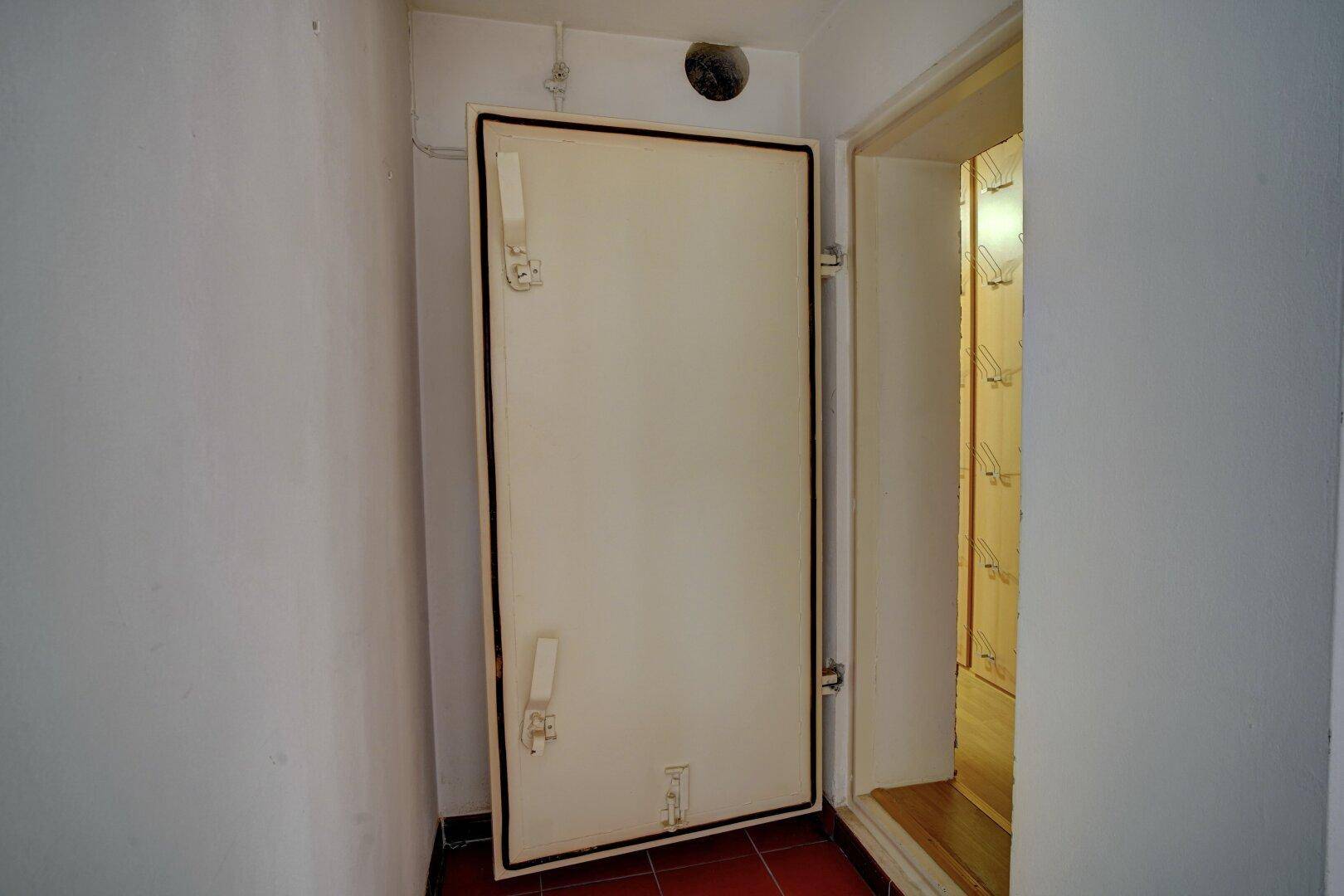 Robuste Kellertür, die zu einem weiteren Lagerbereich oder Schutzraum führt.