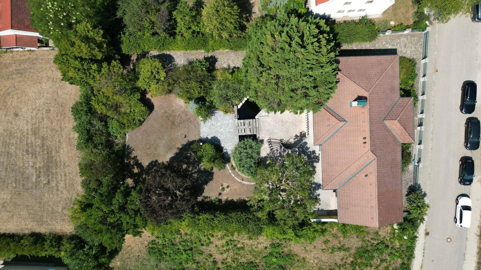 Luftaufnahme des Anwesens mit großem Garten, Villa und umliegender Natur.