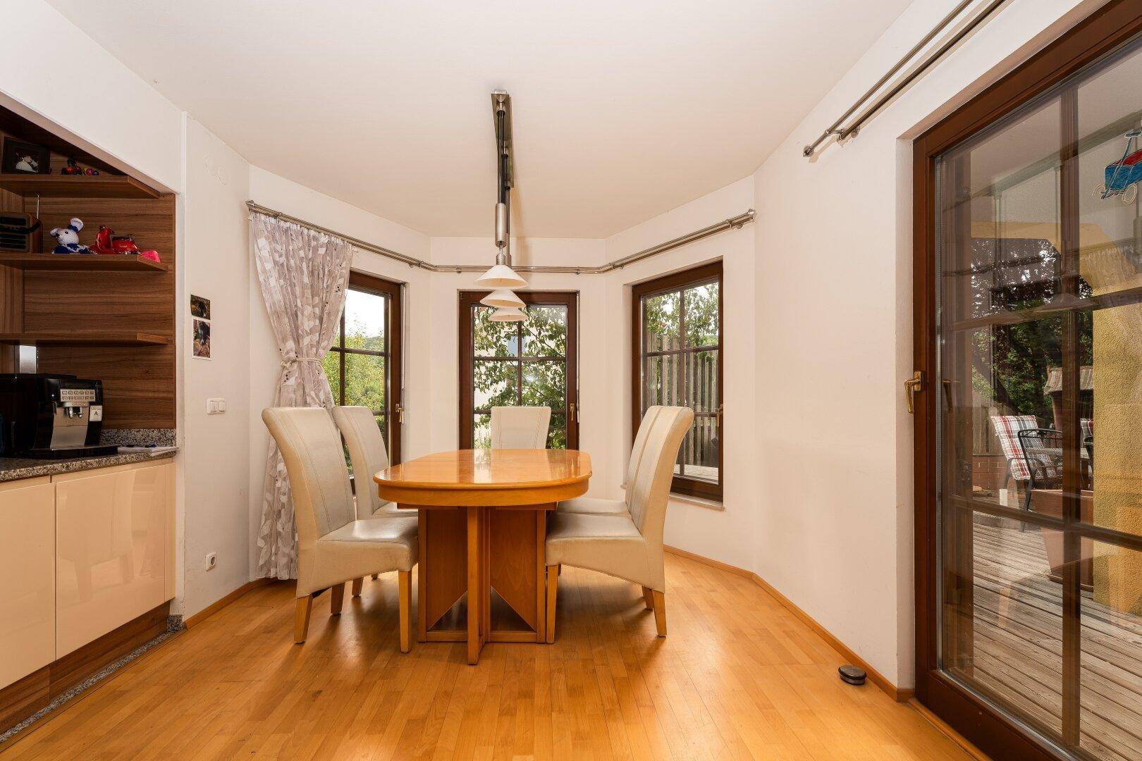 Gemütlicher Essbereich mit Holzboden, großen Fenstern und direktem Zugang zur Terrasse.