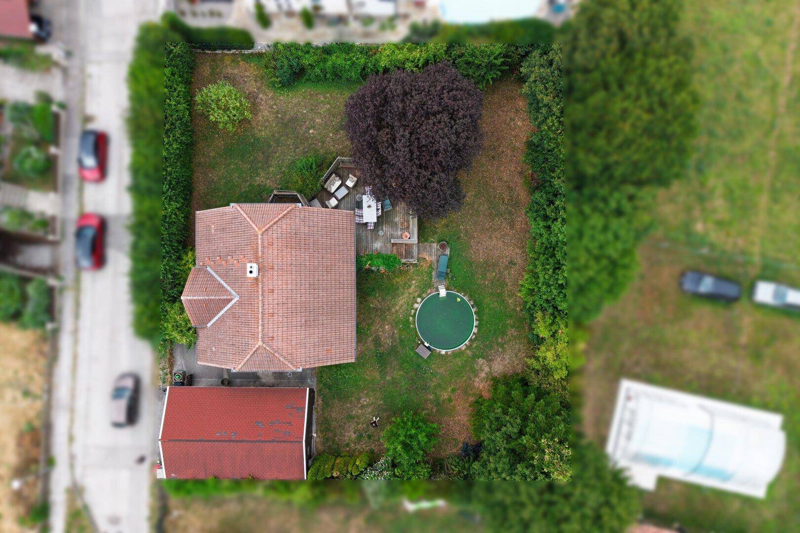 Senkrechte Luftaufnahme des Hauses mit Garten, Pool und angrenzenden Grundstücken.