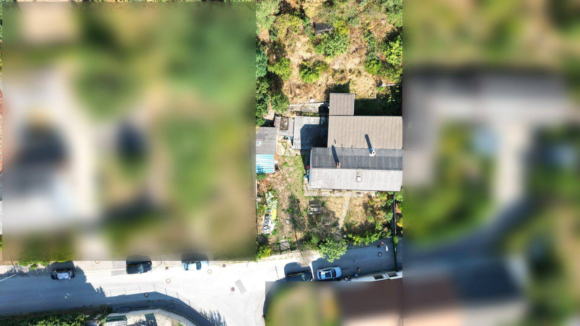 Luftaufnahme des Grundstücks mit dem Haus, Garten und der umliegenden Bebauung und Natur.