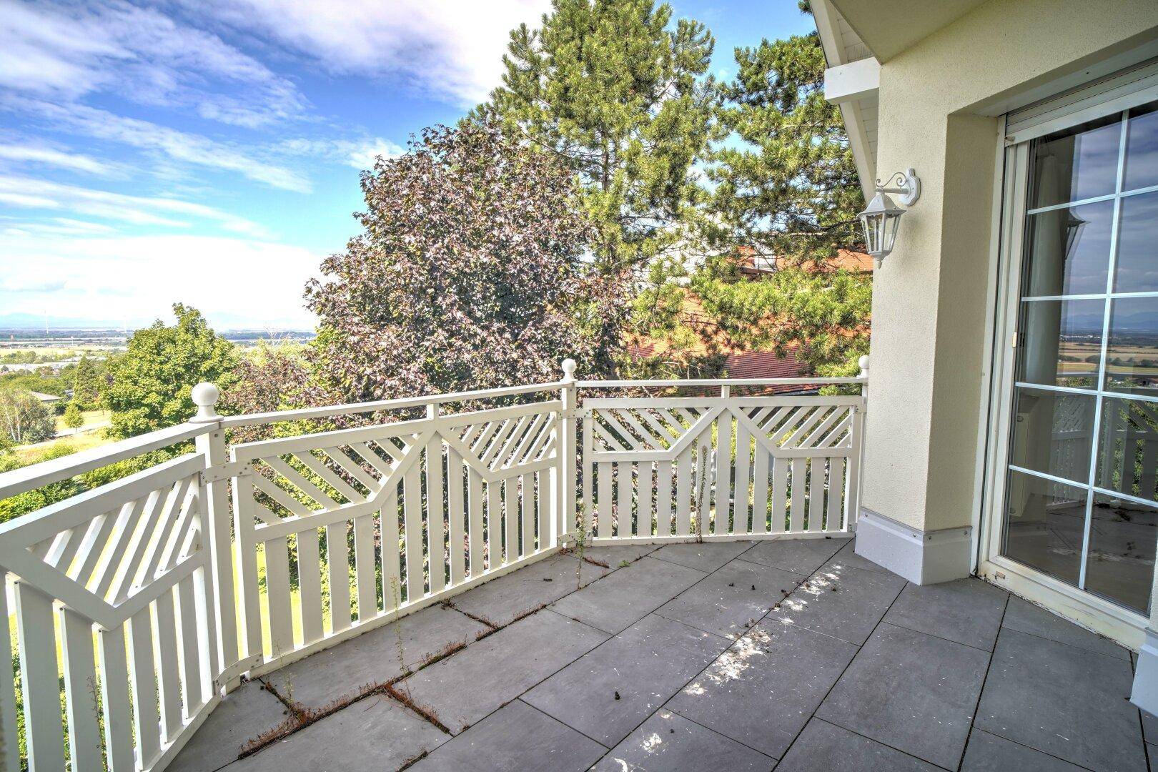 Geräumiger Balkon mit Fliesenboden und weitem Ausblick in die Natur.