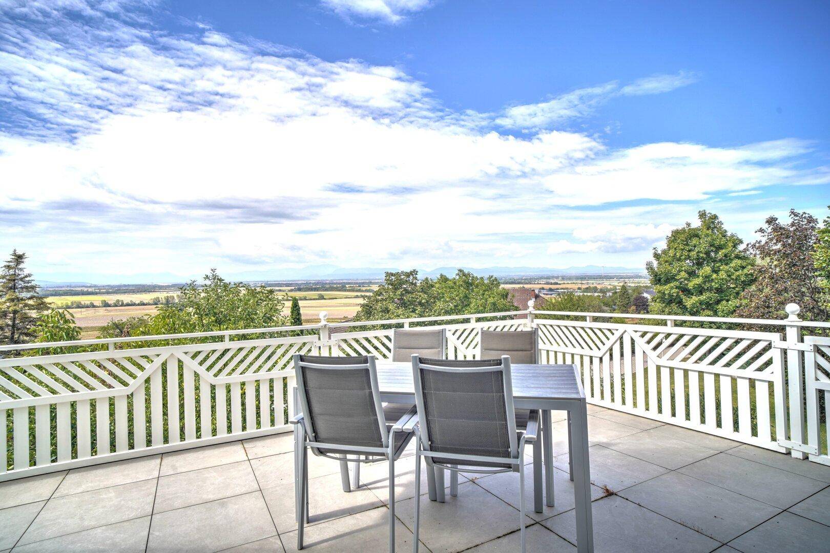 Einladende Terrasse mit modernen Gartenmöbeln und einem atemberaubenden Fernblick über die grüne Landschaft.