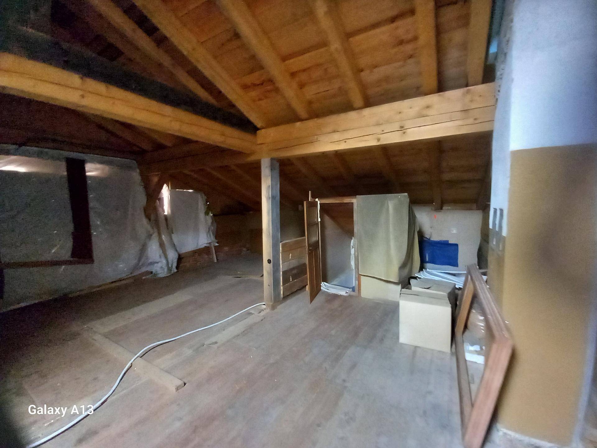Dachbodenbereich mit Holzbalken und Lagerflächen, bietet zusätzlichen Stauraum.