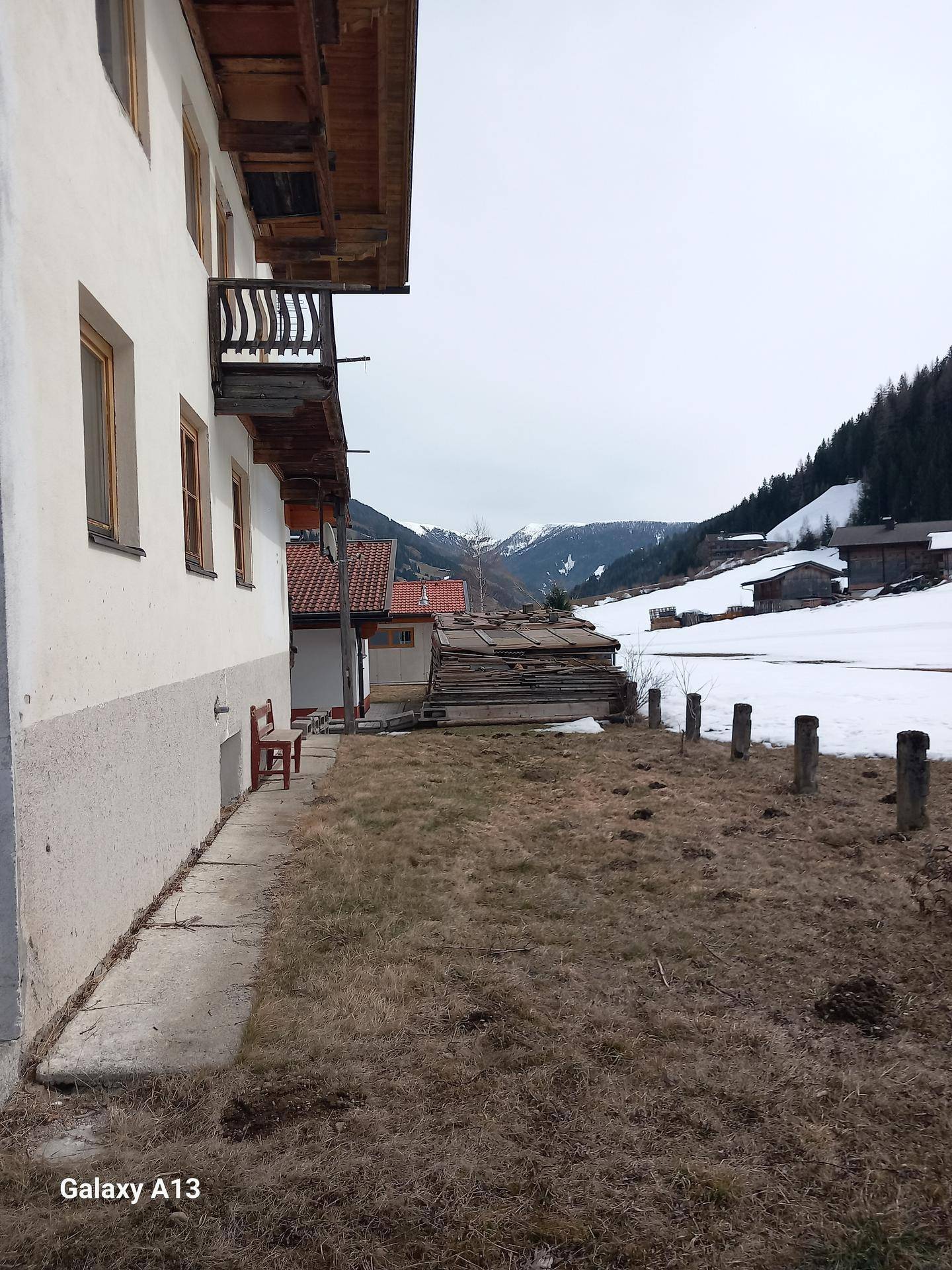 Seitenansicht des Hauses mit einem Gartenbereich und Blick auf die verschneite Berglandschaft.