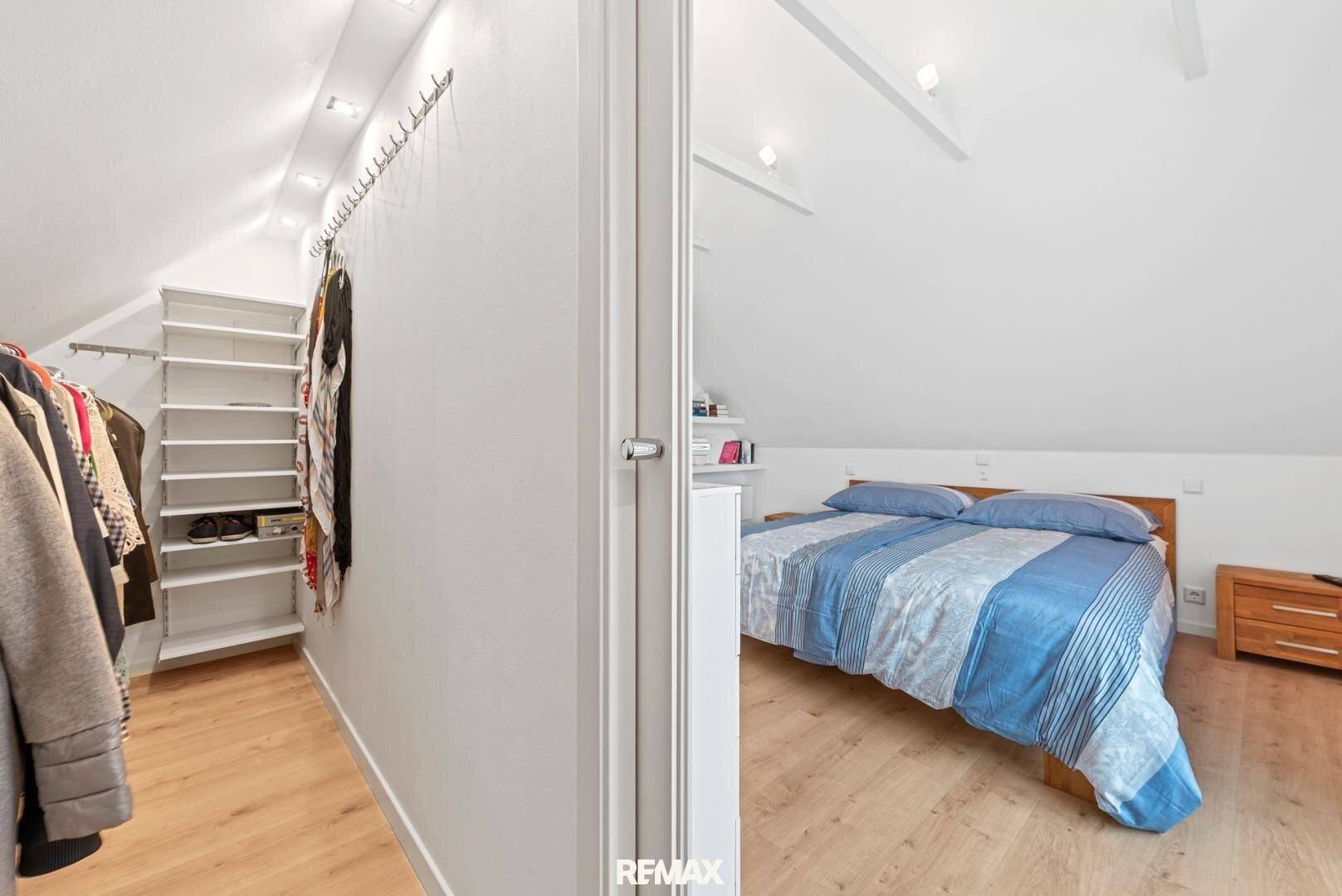 Begehbarer Kleiderschrank mit Regalen und Kleiderstangen, angrenzend an das Schlafzimmer.