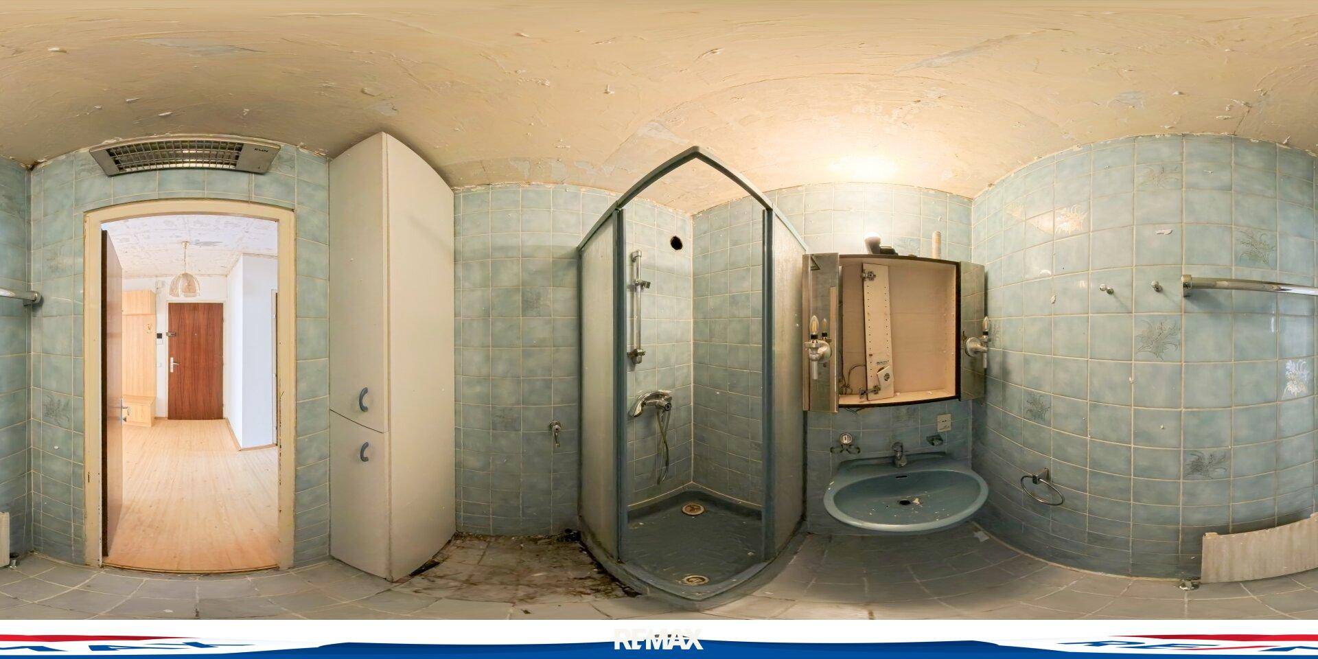 Badezimmer mit blauen Fliesen, einer Duschkabine, Einzelwaschbecken und Spiegelschrank.