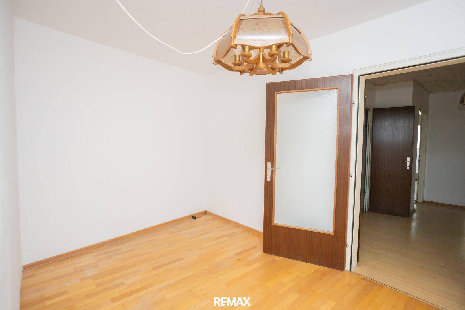 Unmöbliertes Zimmer mit Holzboden und heller Wandfarbe, bereit zur individuellen Gestaltung.