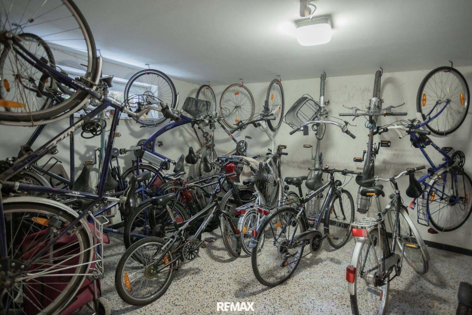 Gemeinschaftlicher Fahrradraum im Keller mit vielen abgestellten Fahrrädern und Stauraum.