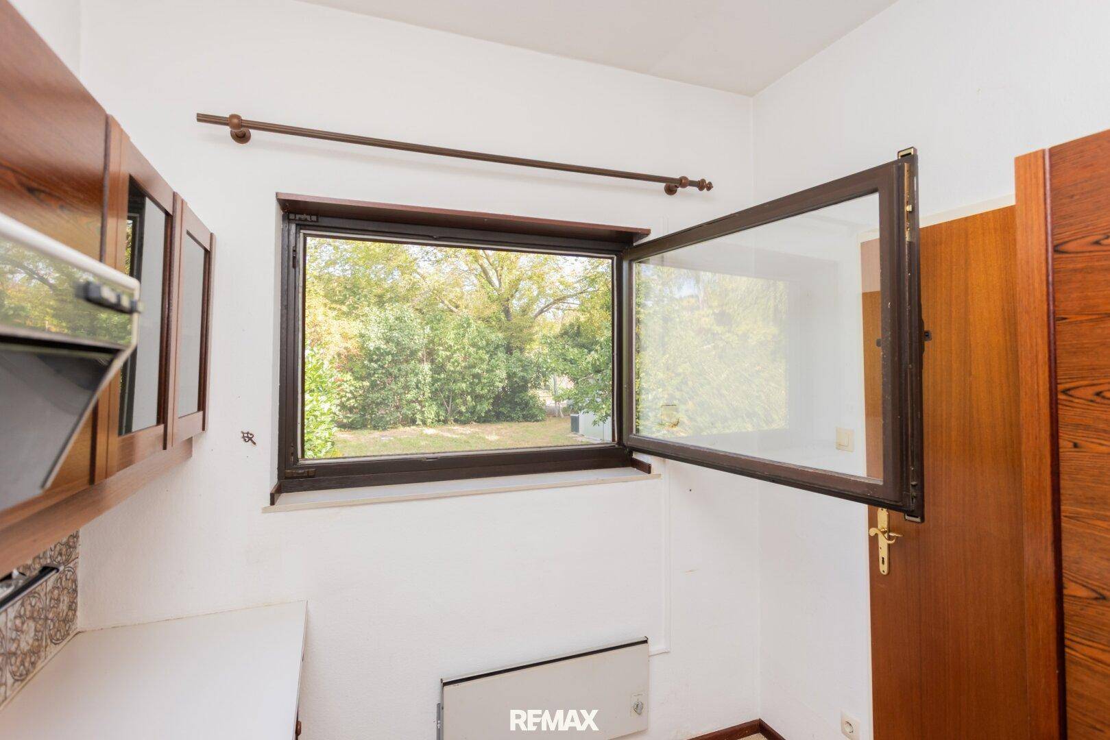 Küchenfenster mit Blick ins Grüne, das viel natürliches Licht in den Raum lässt.