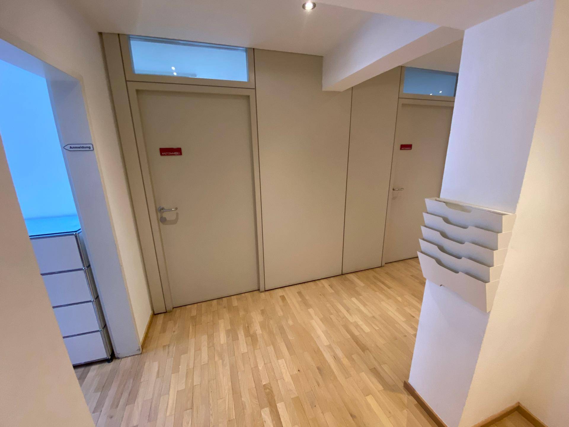 Heller Flur mit Holzboden und mehreren Türen, der zu verschiedenen Räumen führt und gut gepflegt ist.