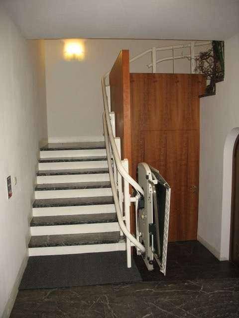 Treppenhaus mit Marmorstufen und einem installierten Treppenlift für barrierefreien Zugang zu den oberen Etagen.
