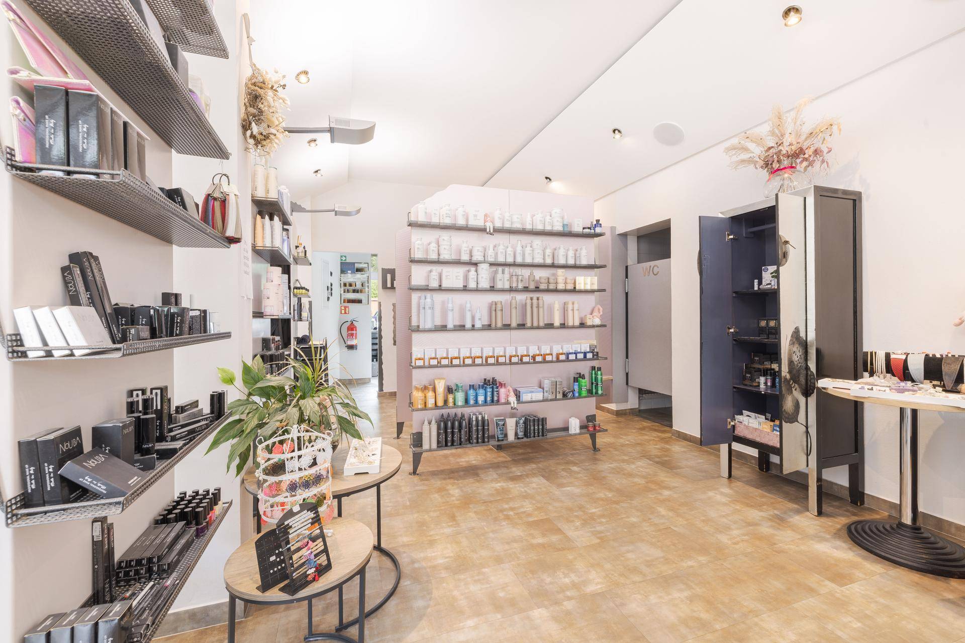 Innenansicht eines Salons mit umfangreichen Produktregalen und heller Beleuchtung.