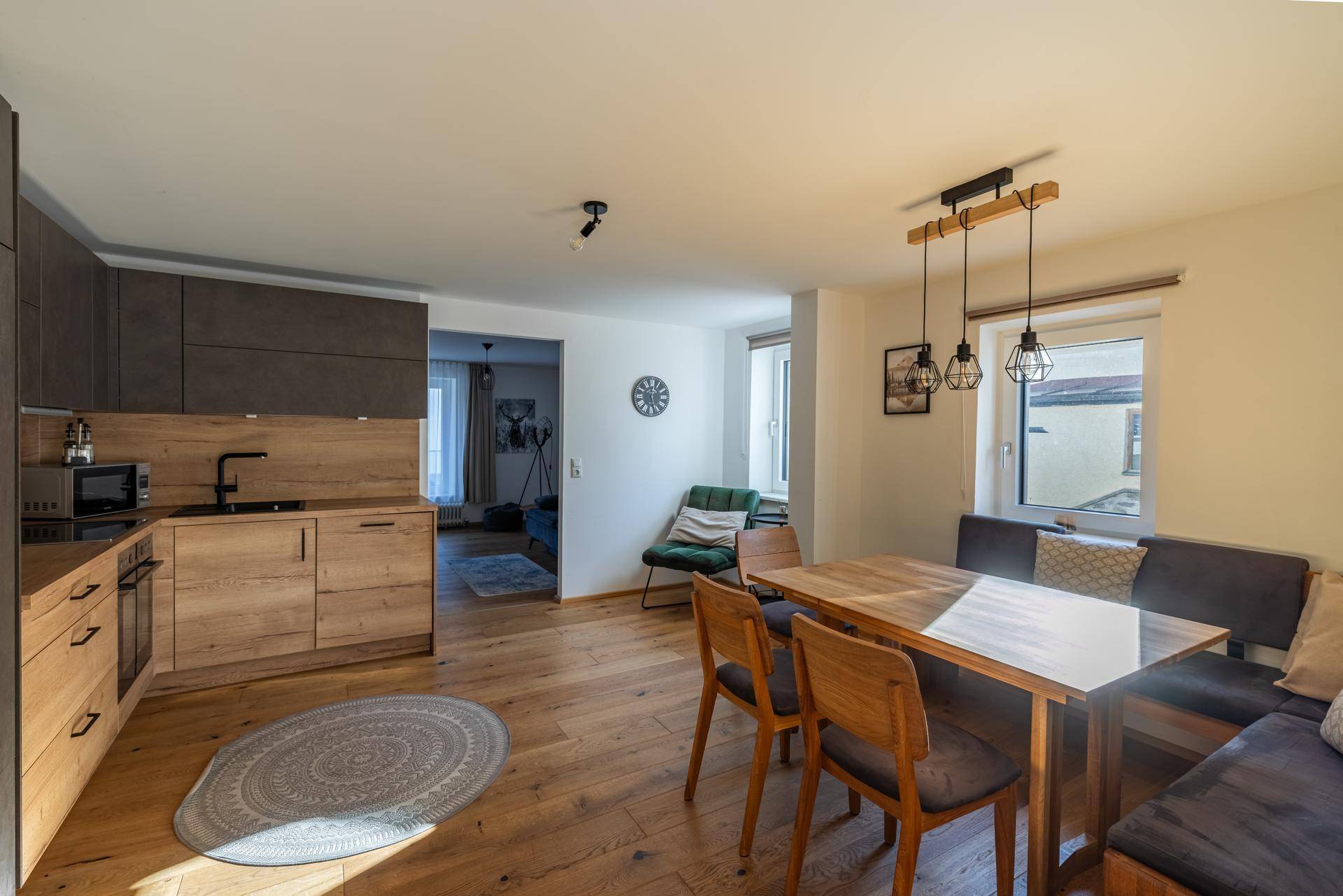 Moderne Küche mit Holzelementen und Essbereich, offen gestaltet mit Holzboden.