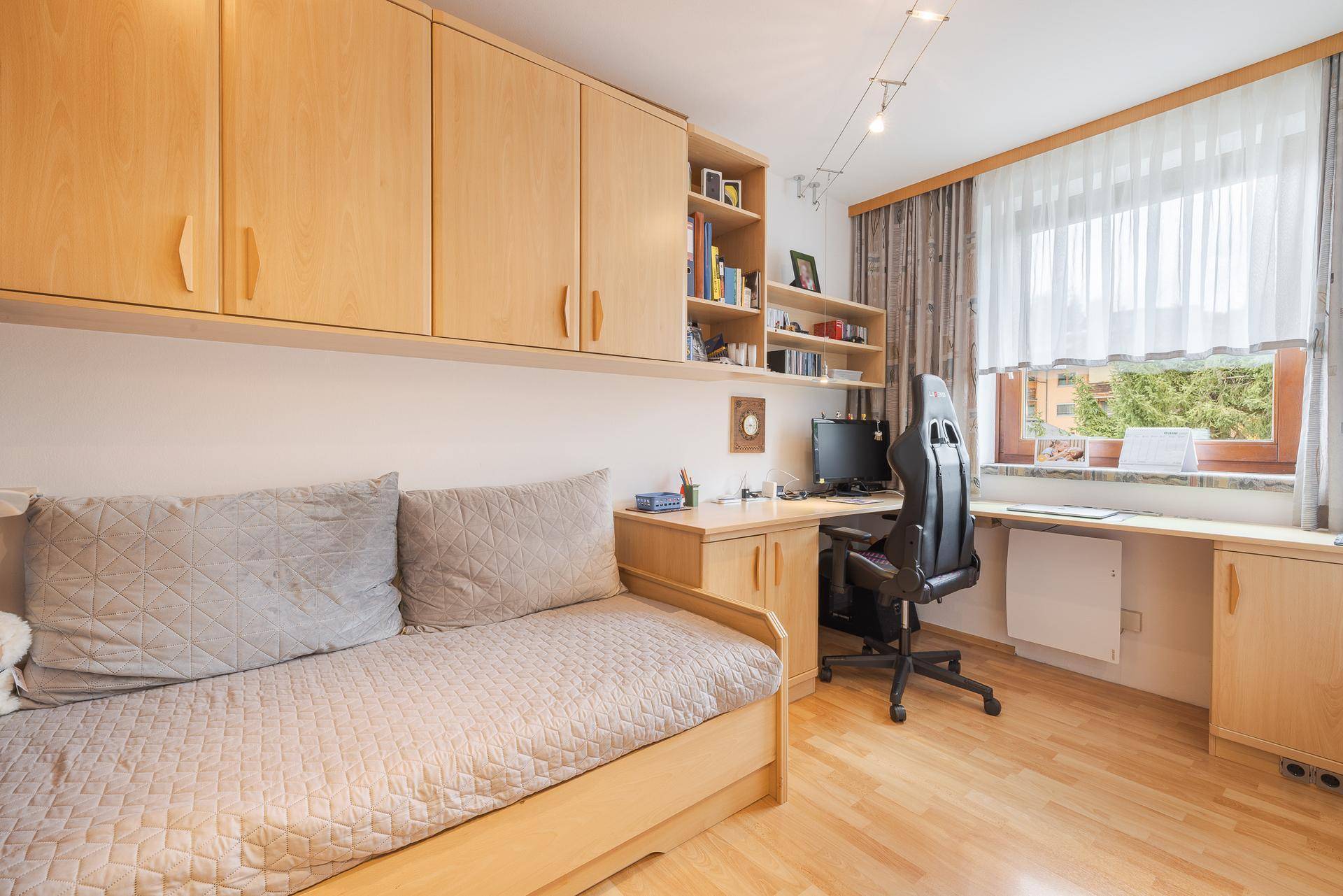 Helles Arbeitszimmer mit Schreibtisch, Stauraum und Holzboden, ideal für Home-Office.