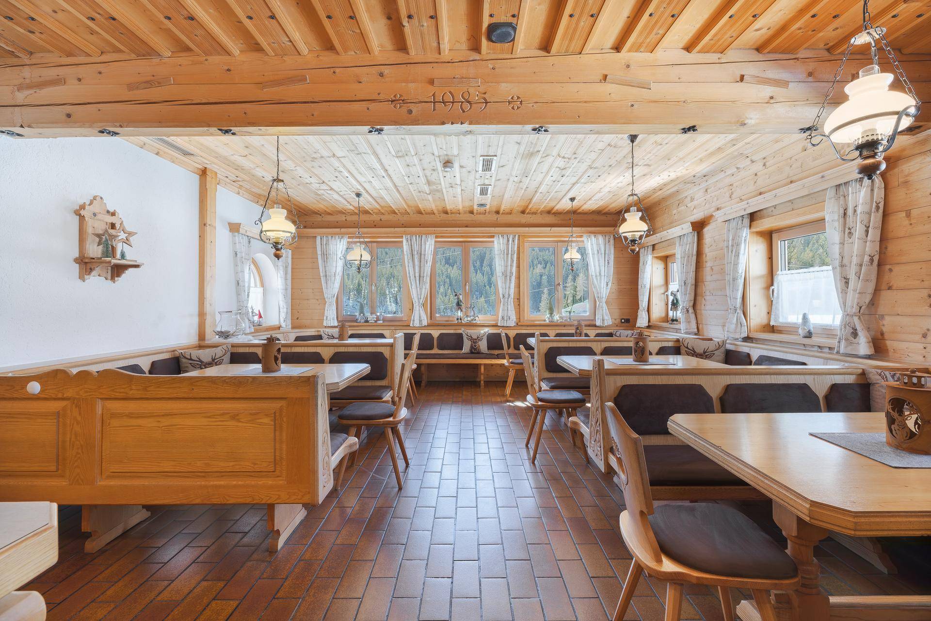 Geräumiger Essbereich mit Holzwänden, Holzbalkendecke und traditionellen Sitzgelegenheiten.