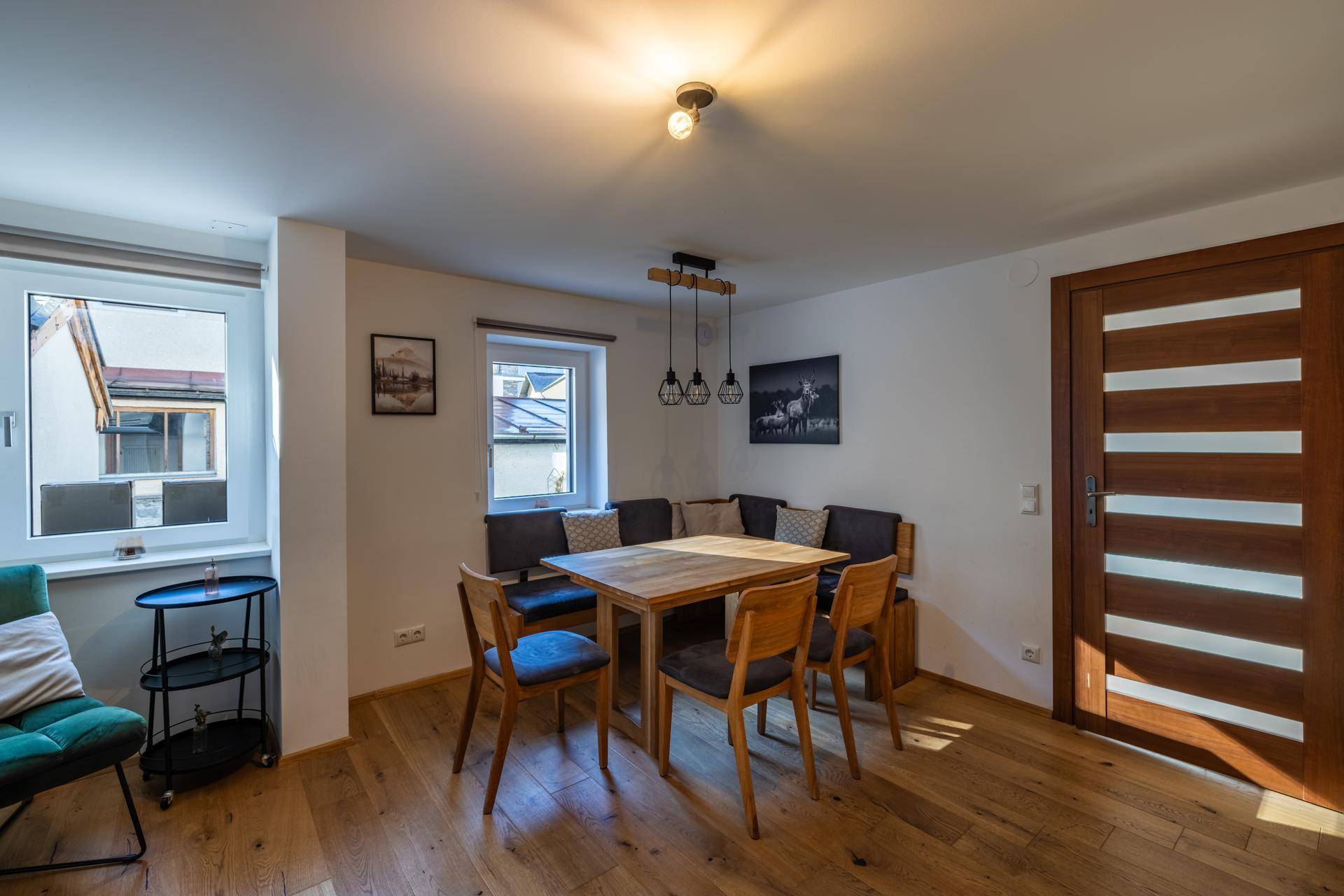 Gemütlicher Essbereich mit Holztisch, Eckbank und Pendelleuchten, ideal für Mahlzeiten.