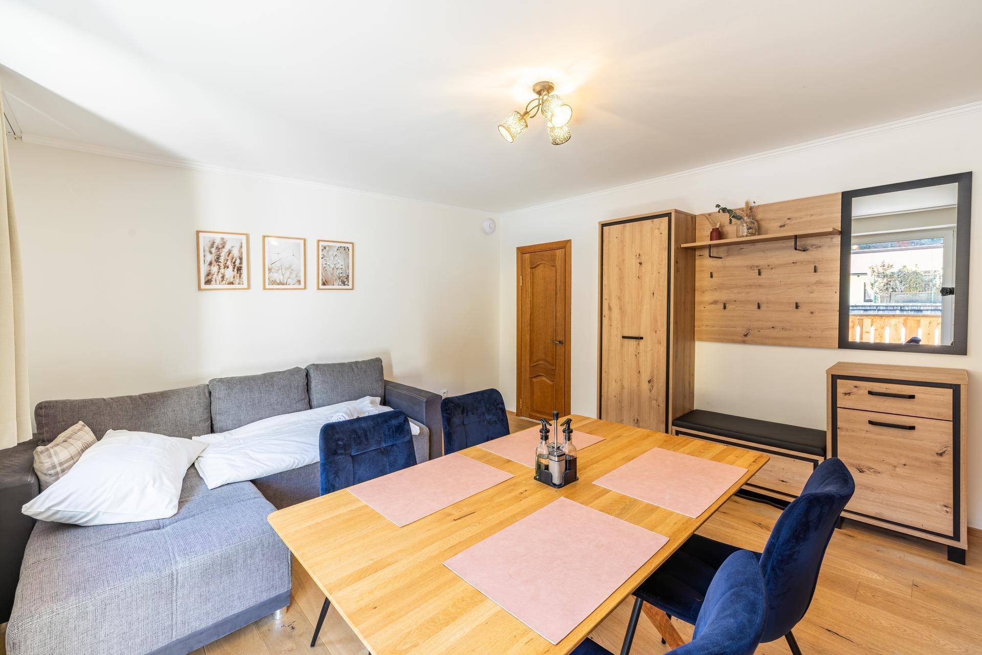 Wohn- und Essbereich mit Holzboden, Esstisch und Garderobe, ideal für Familien.