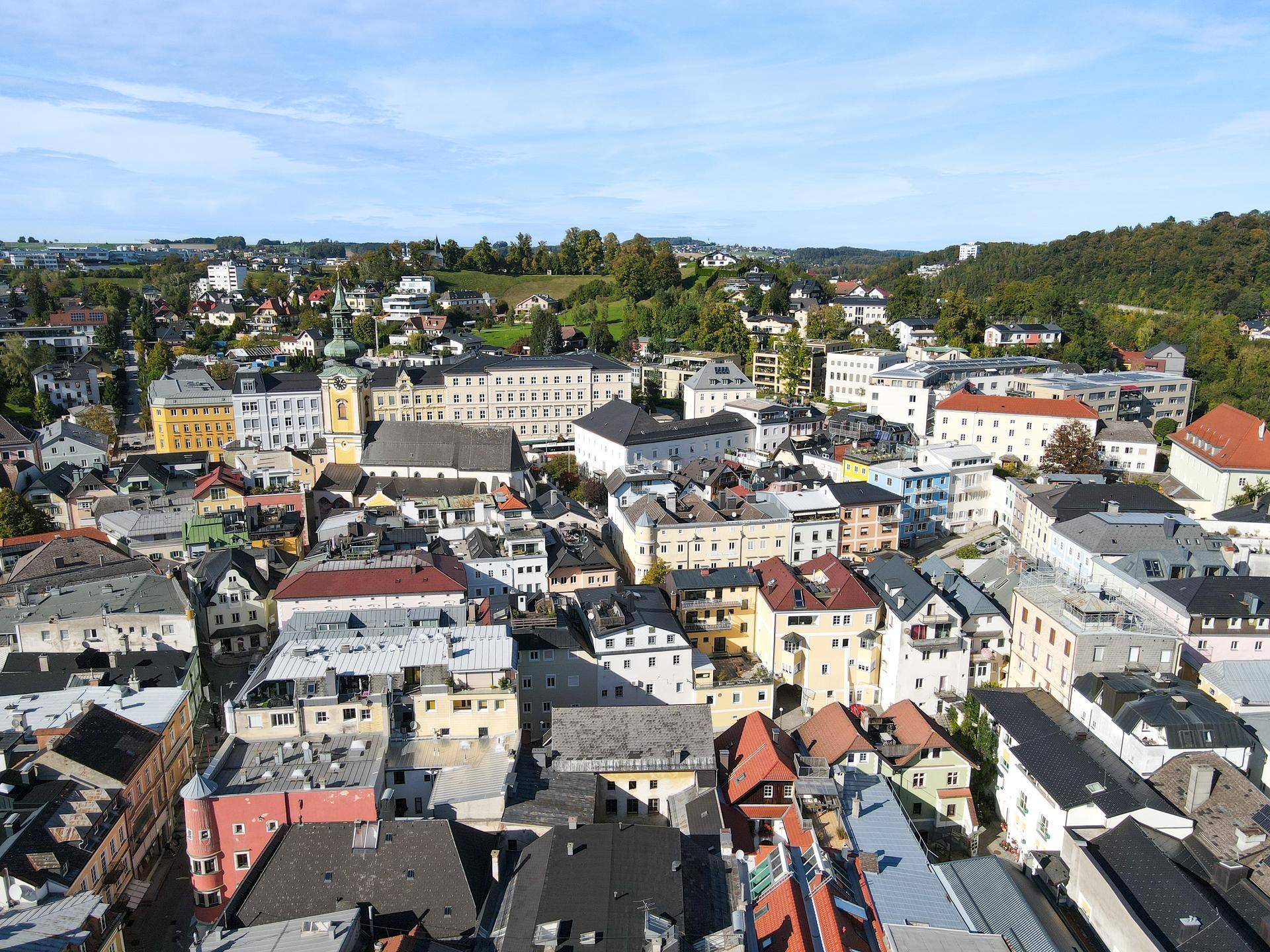 Panoramablick über die Dächer der Stadt Gmunden mit Wohngebieten und grünen Hügeln im Hintergrund.