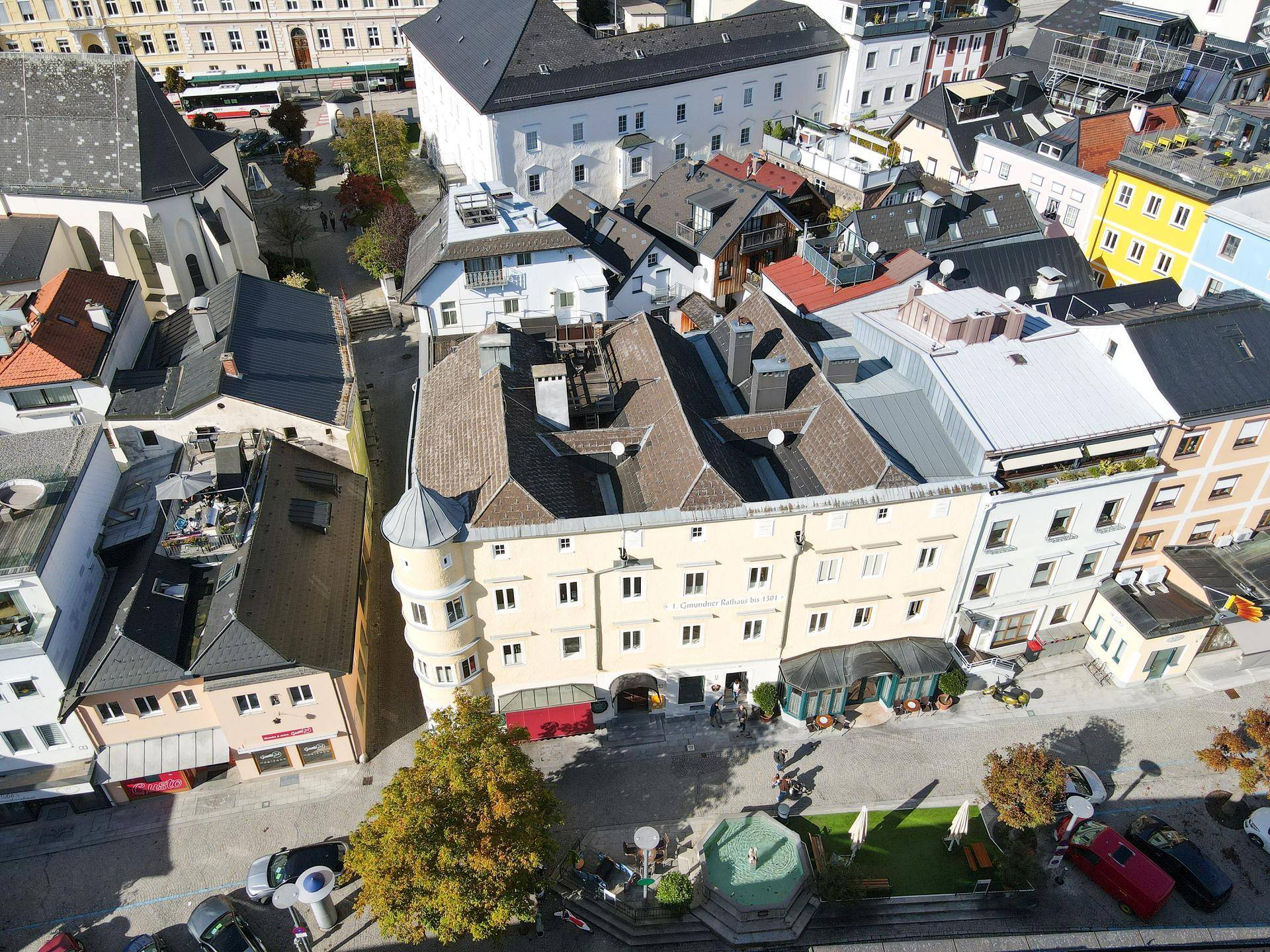 Panoramablick von oben auf ein historisches Gebäude und die umliegende Stadtarchitektur mit verschiedenen Dächern.