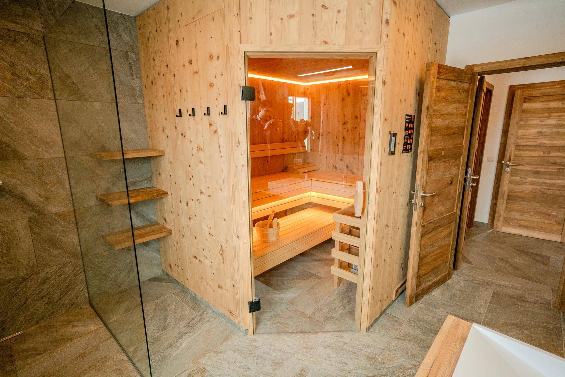 Modernes Badezimmer mit integrierter Sauna und Glasdusche, bietet Wellness und Entspannung.