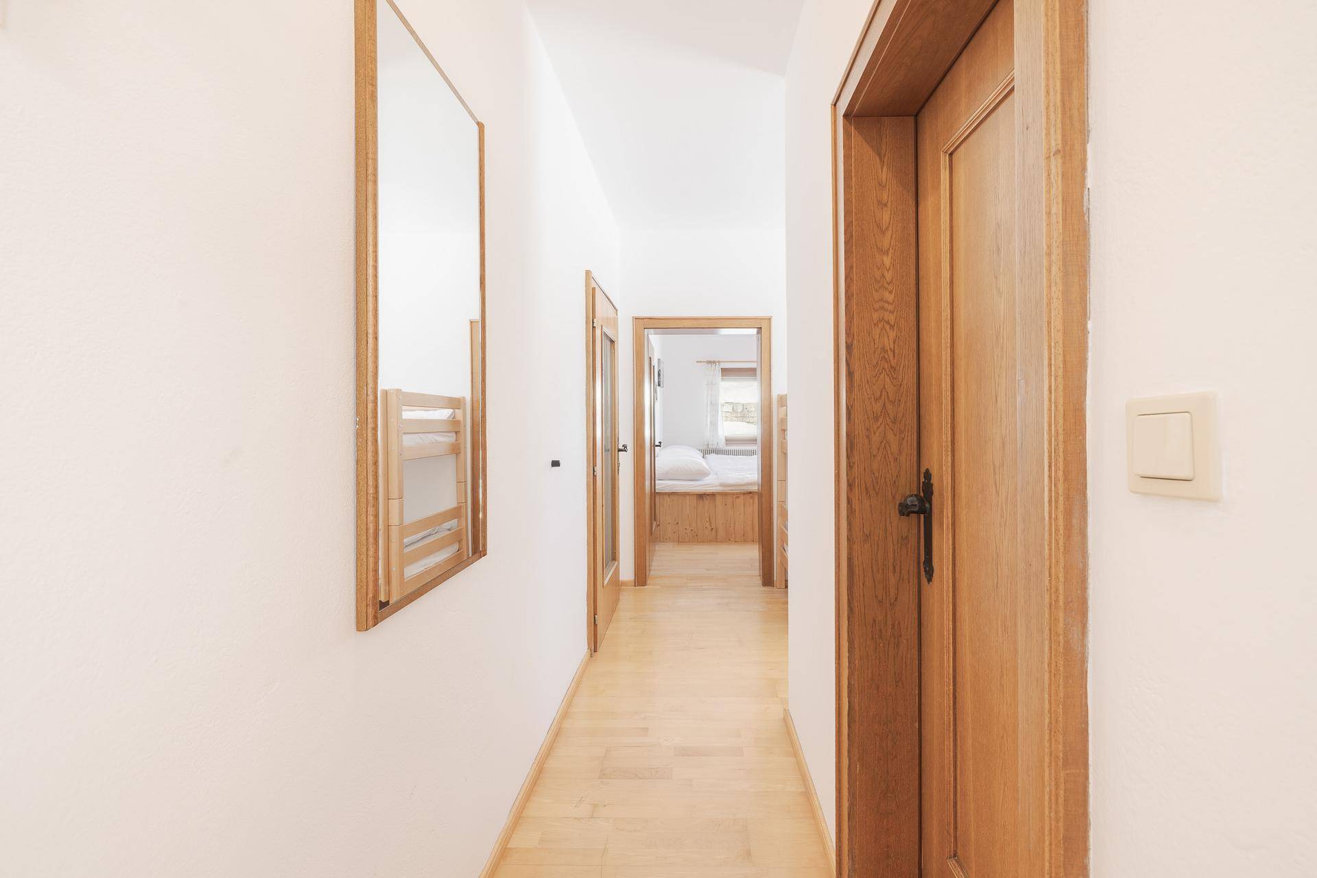 Heller Flur mit Holztüren, Spiegel und Blick in weitere Zimmer.