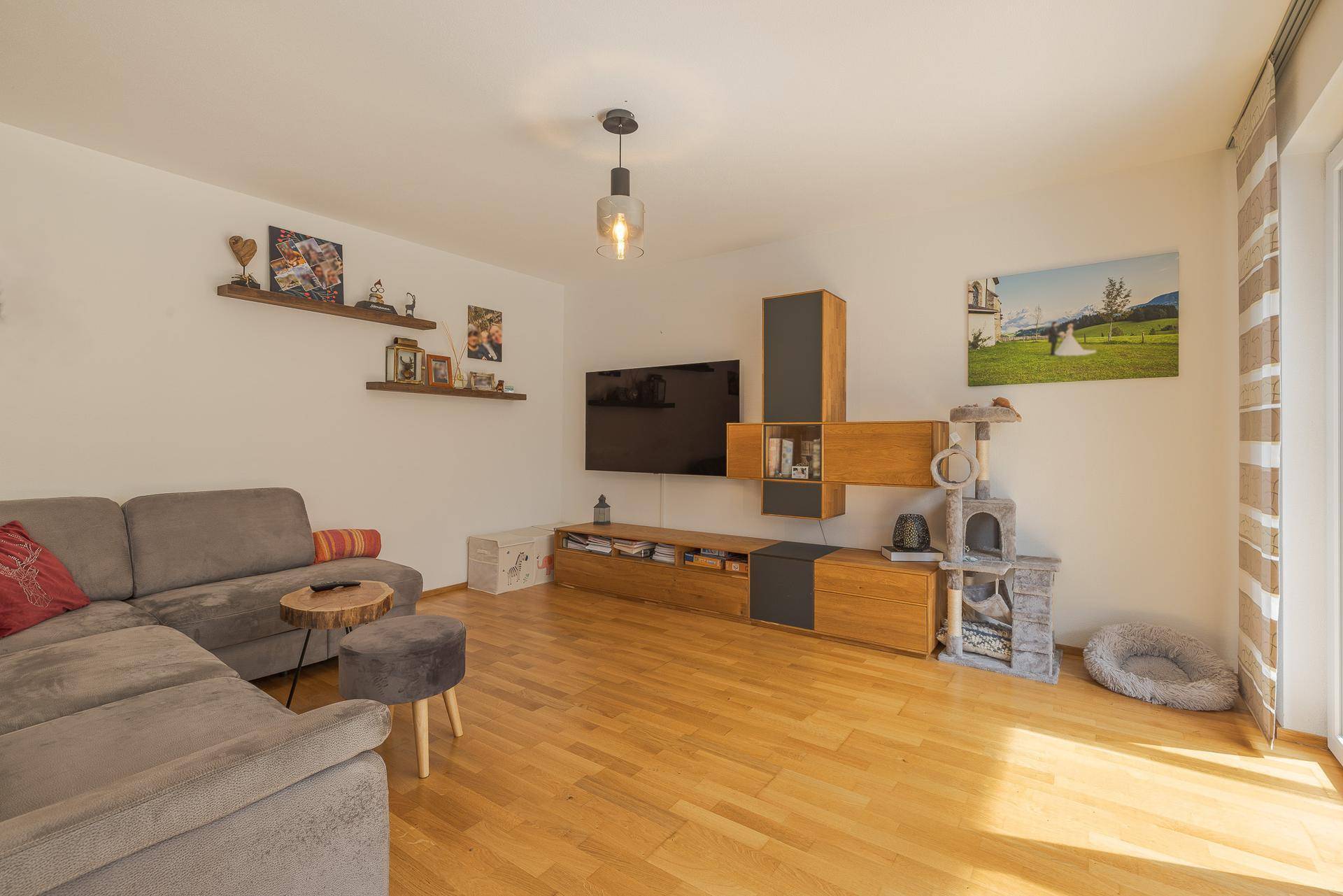 Gemütliches Wohnzimmer mit Holzboden und moderner Medieneinheit für entspannte Abende.