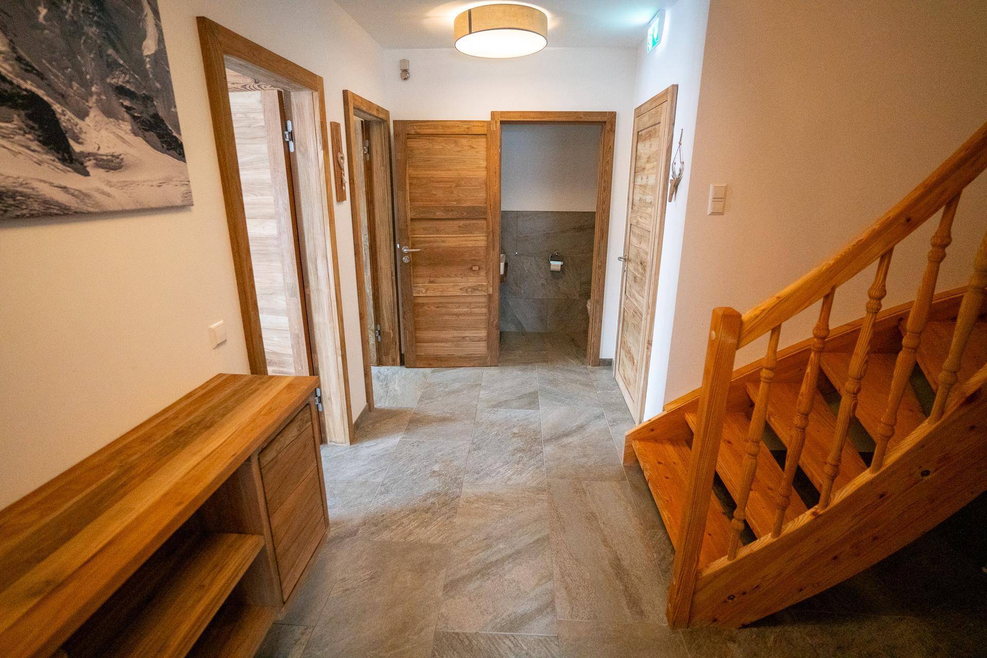 Heller Flur mit Holztreppe und Holztüren, verbindet die verschiedenen Bereiche des Hauses.