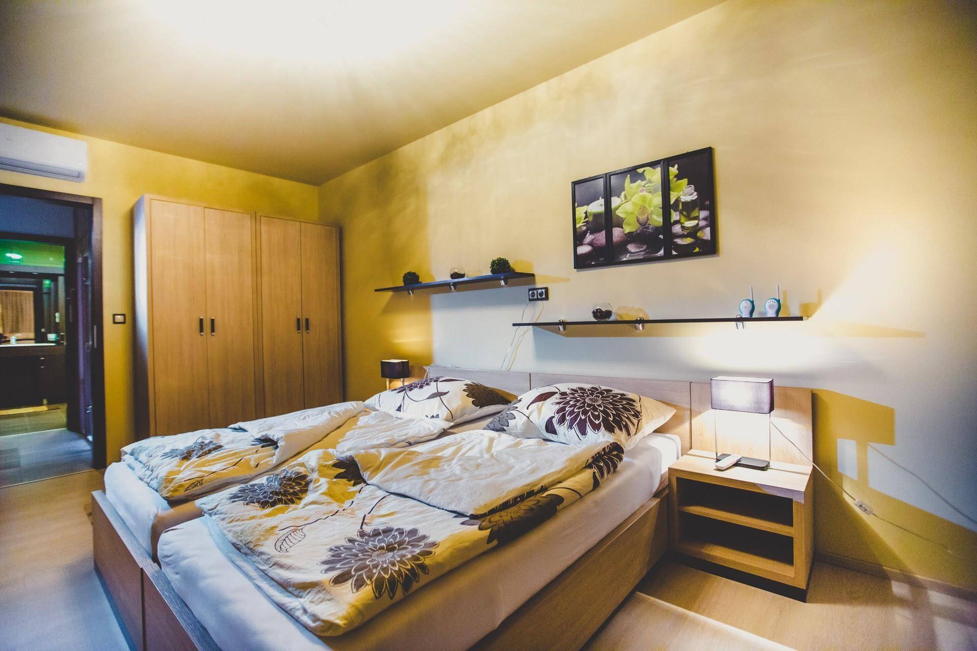 Gemütliches Schlafzimmer mit zwei Einzelbetten, Holzschränken und warmen gelben Wänden.