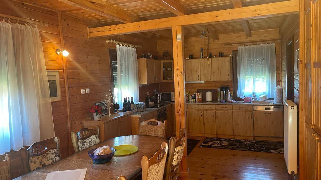 Offener Wohn- und Essbereich mit angrenzender Küche, alles in warmem Holz gehalten.