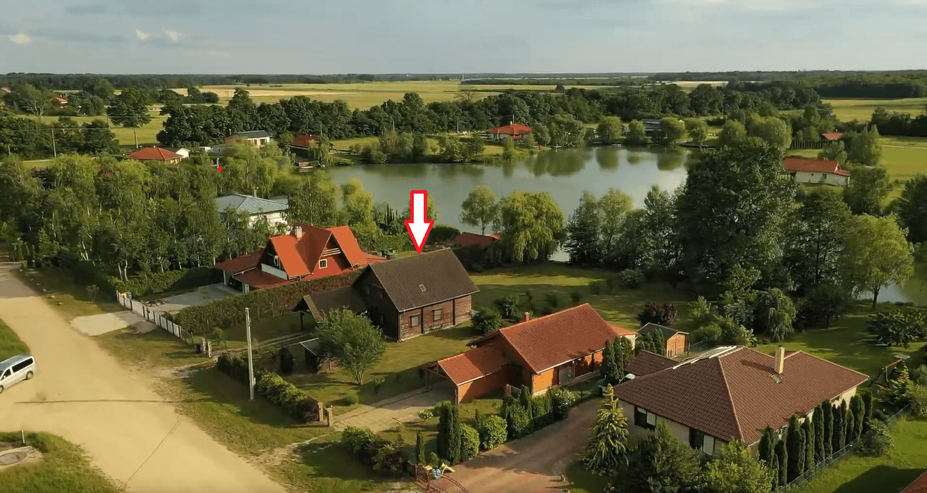 Weitläufige Luftaufnahme eines Wohngebiets mit Seen und viel Grün, das Zielobjekt ist markiert.