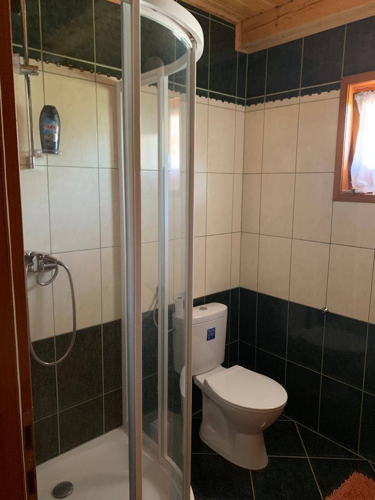 Badezimmer mit Duschkabine, wandhängendem WC und kontrastreichen schwarz-weißen Fliesen.
