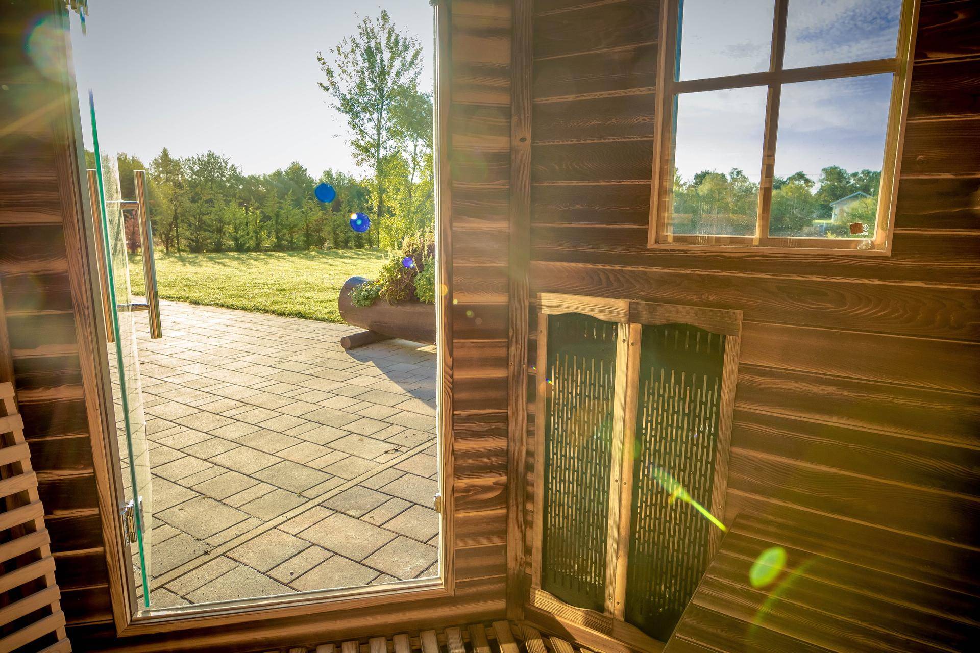 Innenansicht der Holzsauna mit Holzbänken und Blick nach draußen.