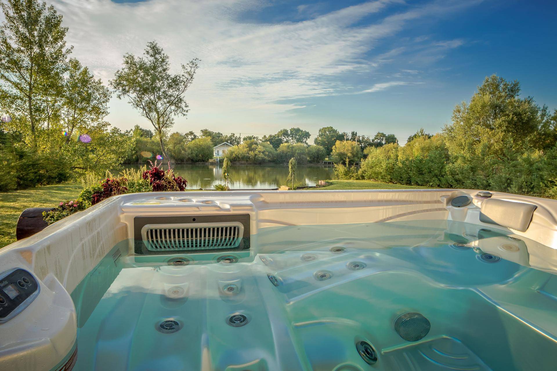 Whirlpool im Gartenbereich mit Blick auf den See und die umliegende Natur.
