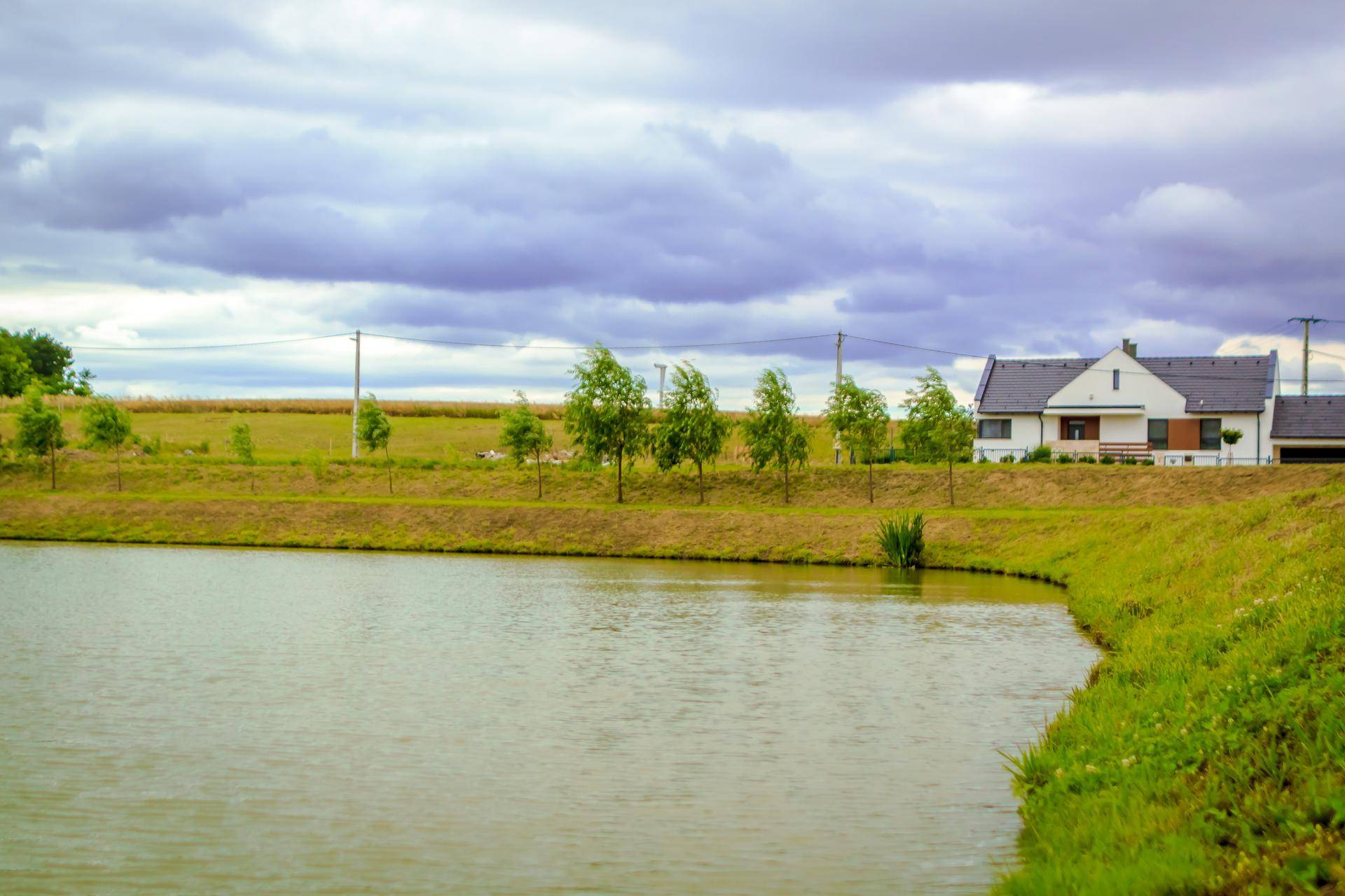 Ein Haus am Seeufer mit weitem Blick über das Wasser und die ländliche Landschaft.