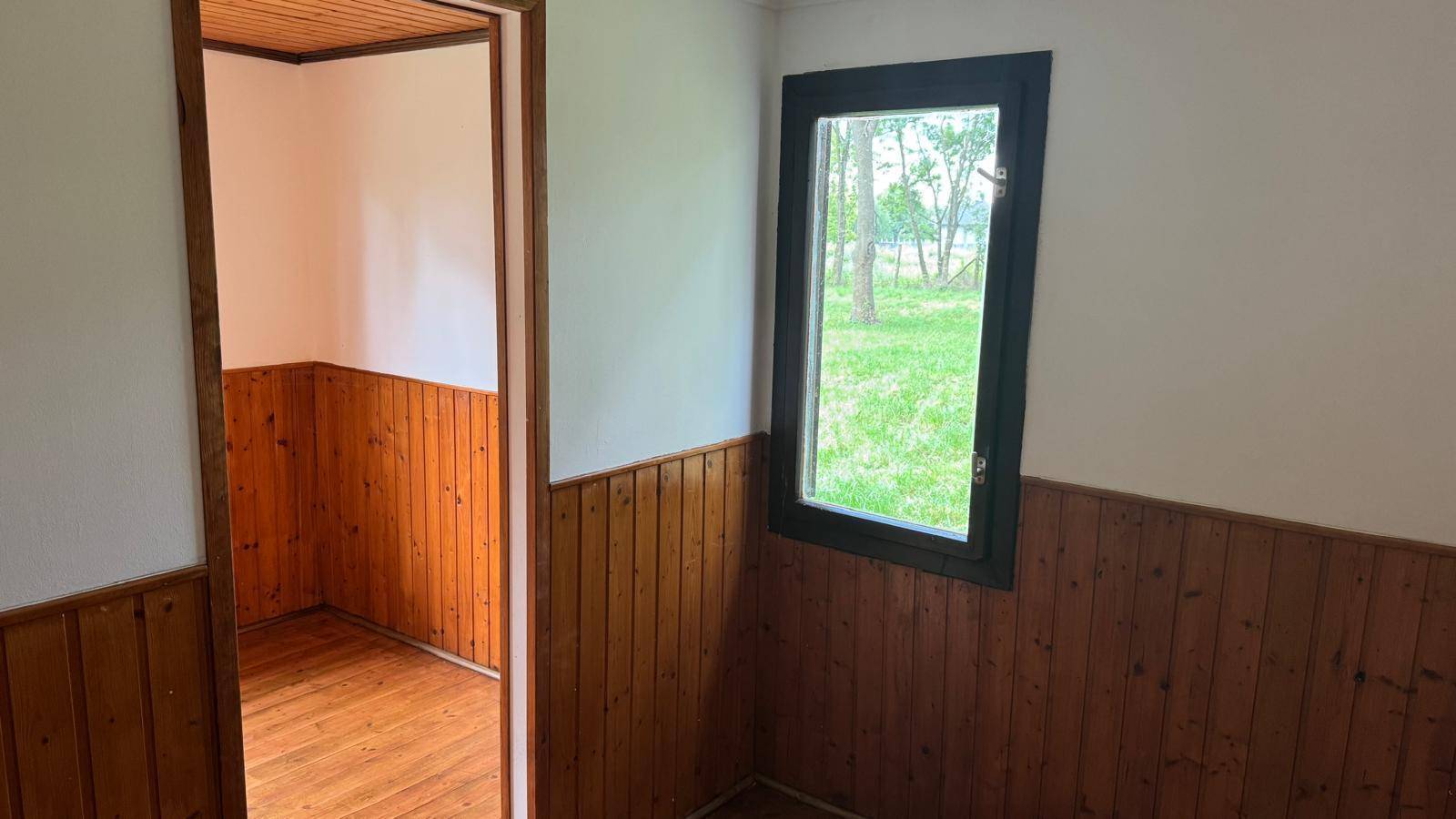 Heller Innenraum mit Holzvertäfelung und einem Fenster, das viel Tageslicht hereinlässt.