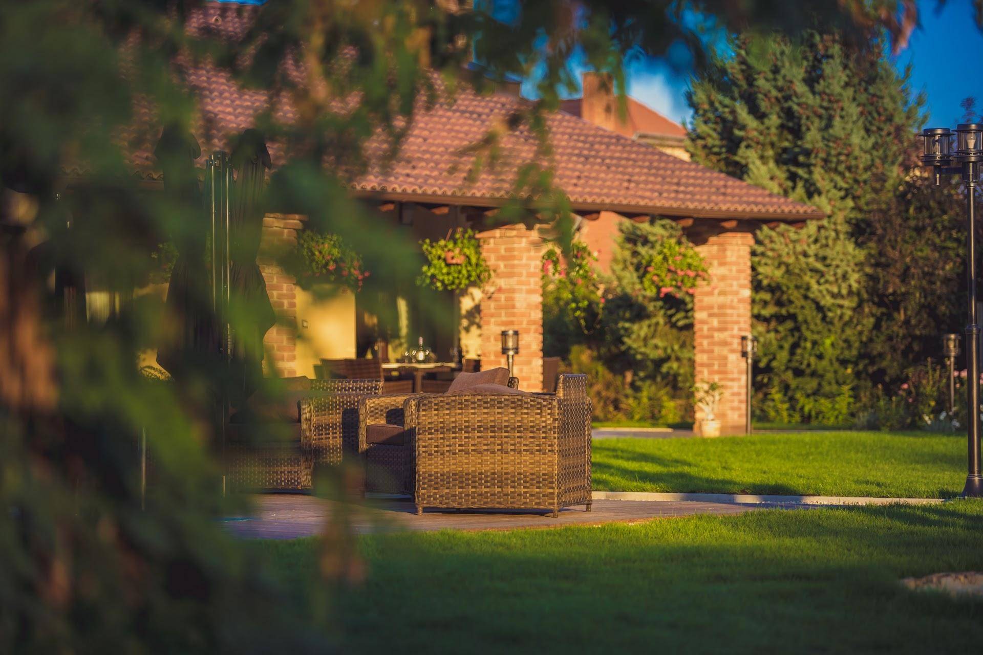 Gemütlicher Lounge-Bereich auf der Terrasse mit Blick auf den grünen Garten und die überdachte Veranda.