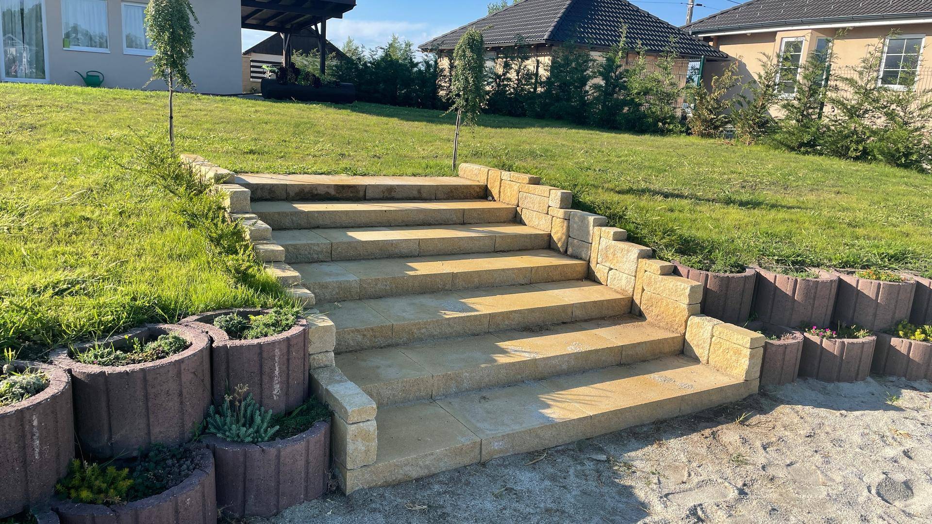 Steintreppe im Gartenbereich mit dekorativen Pflanzgefäßen.