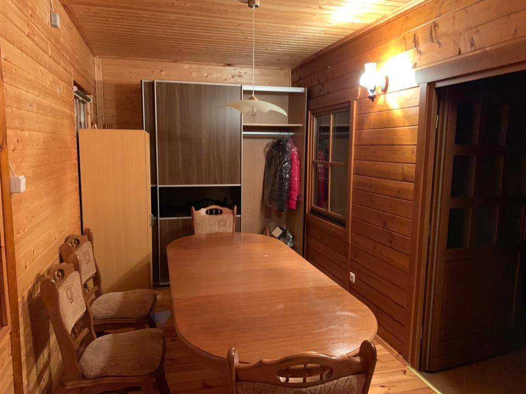 Esszimmer mit Holztisch, Stühlen und einem großen Einbauschrank in rustikalem Ambiente.