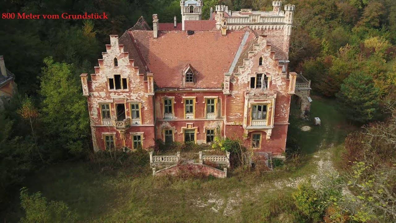 Altes, verfallenes Herrenhaus mit markanter Architektur und umgebender Natur.