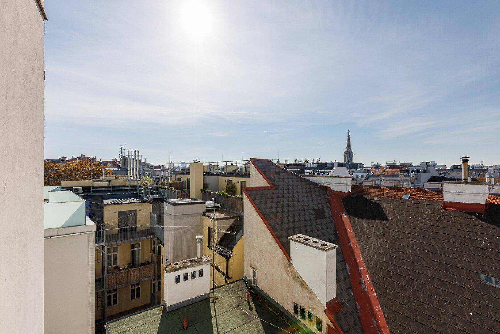 Weitläufiger Blick über die Dächer der Stadt an einem sonnigen Tag.