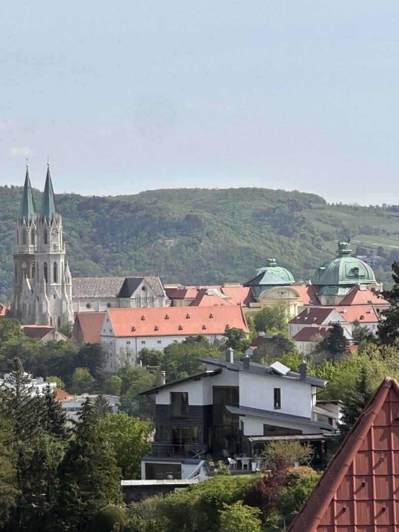 Historische Architektur mit einer Kirche und weiteren Gebäuden, eingebettet in eine grüne Landschaft.