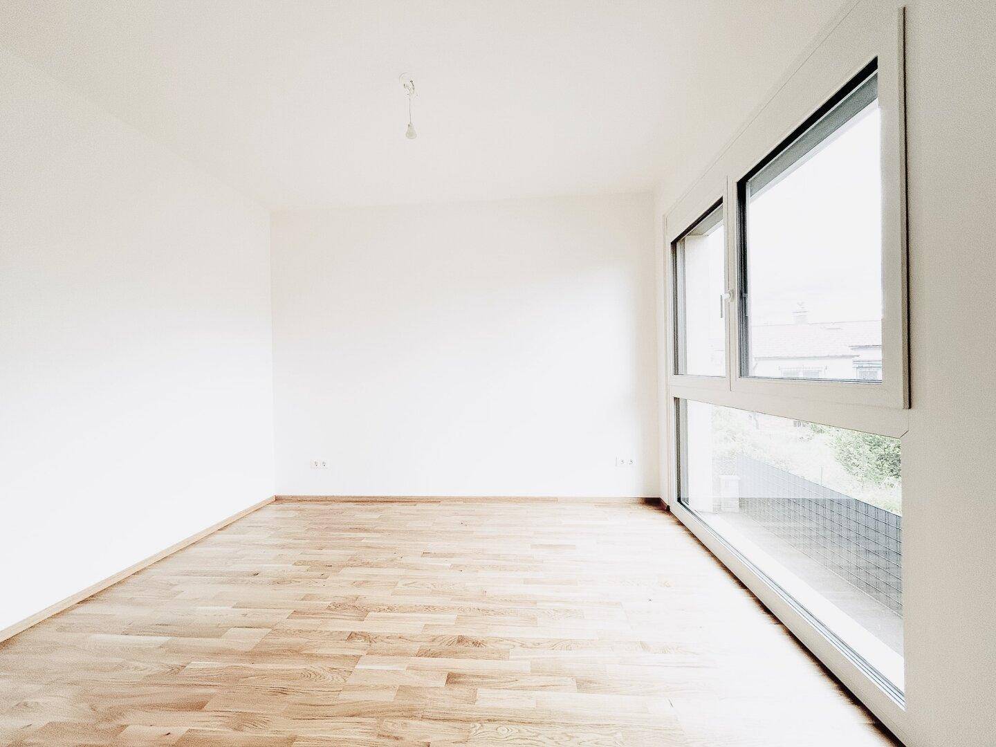 Geräumiges, helles Zimmer mit Parkettboden und großen Fenstern, ideal für individuelle Gestaltung.