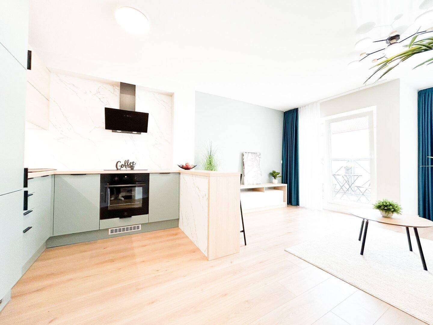 Moderne Küche mit hellblauen Schränken, integriertem Backofen und Dunstabzugshaube.