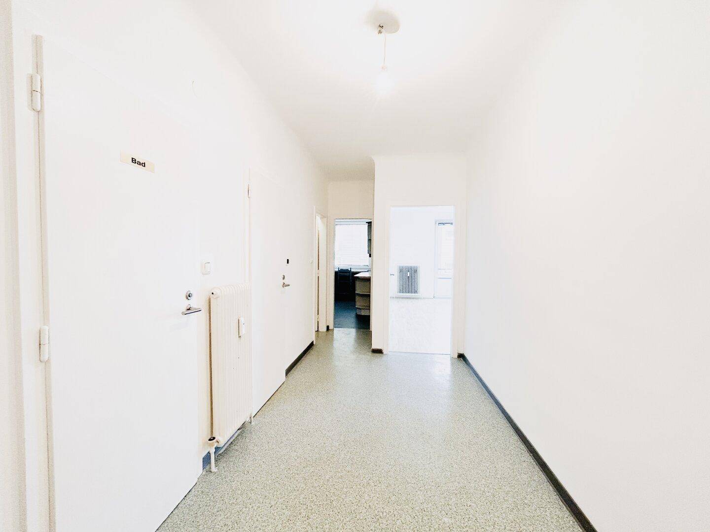 Heller Flur mit hellem Boden und Zugang zu verschiedenen Räumen der Wohnung.