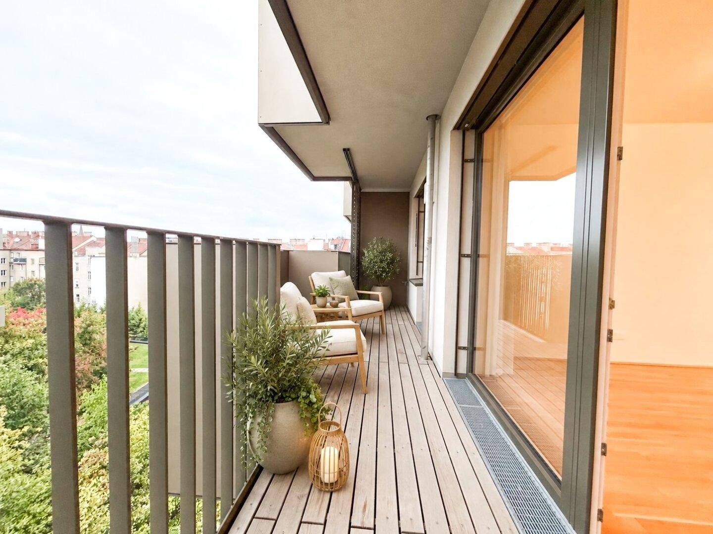 Gemütlicher Balkon mit Holzboden, Sitzgelegenheiten und Pflanzen, ideal zum Entspannen.