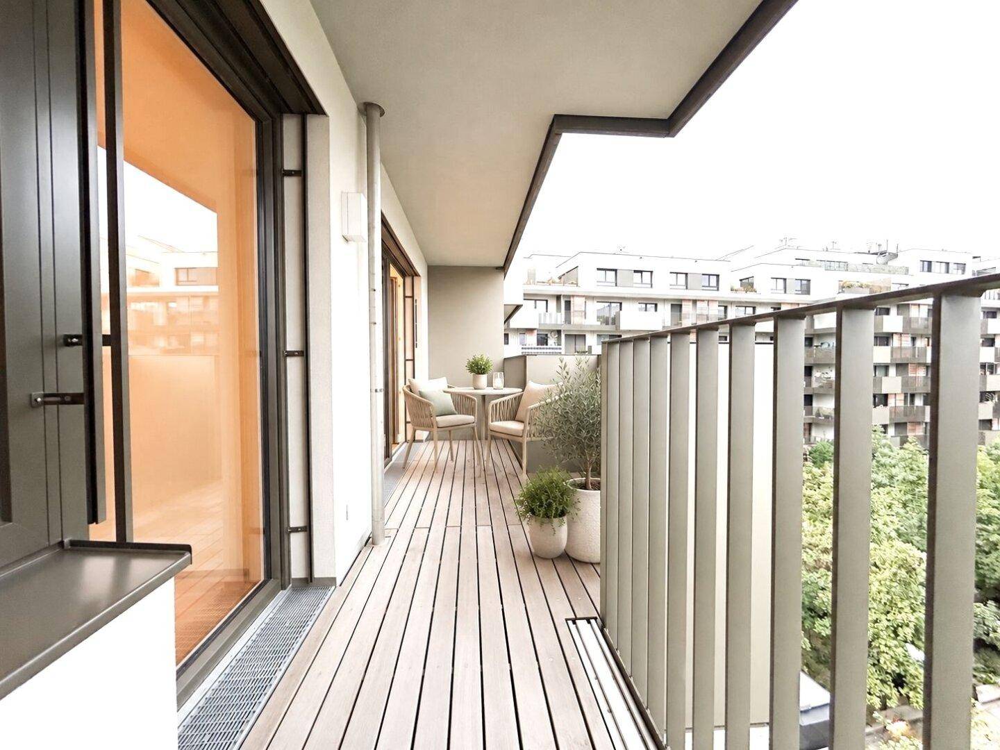 Möblierter Balkon mit Holzboden und Blick auf die Stadt, ideal für entspannte Stunden.
