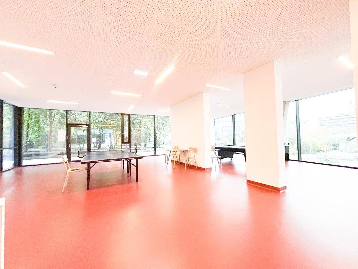 Großer Gemeinschaftsraum mit Tischtennisplatte und Billardtisch für Bewohner.