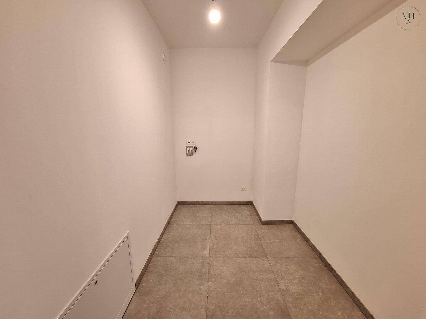 Praktischer Hauswirtschaftsraum mit Fliesenboden und Anschlüssen für Waschmaschine und Trockner.